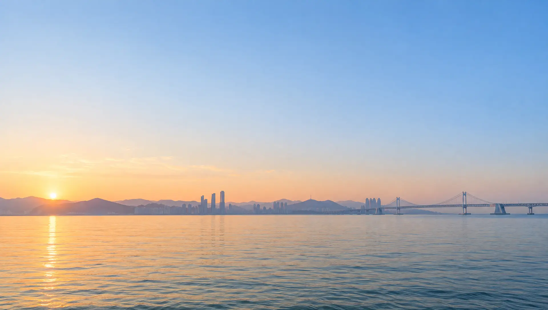 해 뜨는 부산 바다와 멀리 보이는 광안대교